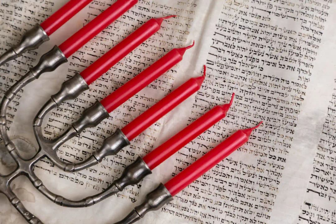 A multibranched candelabra on a book with Jewish scripture